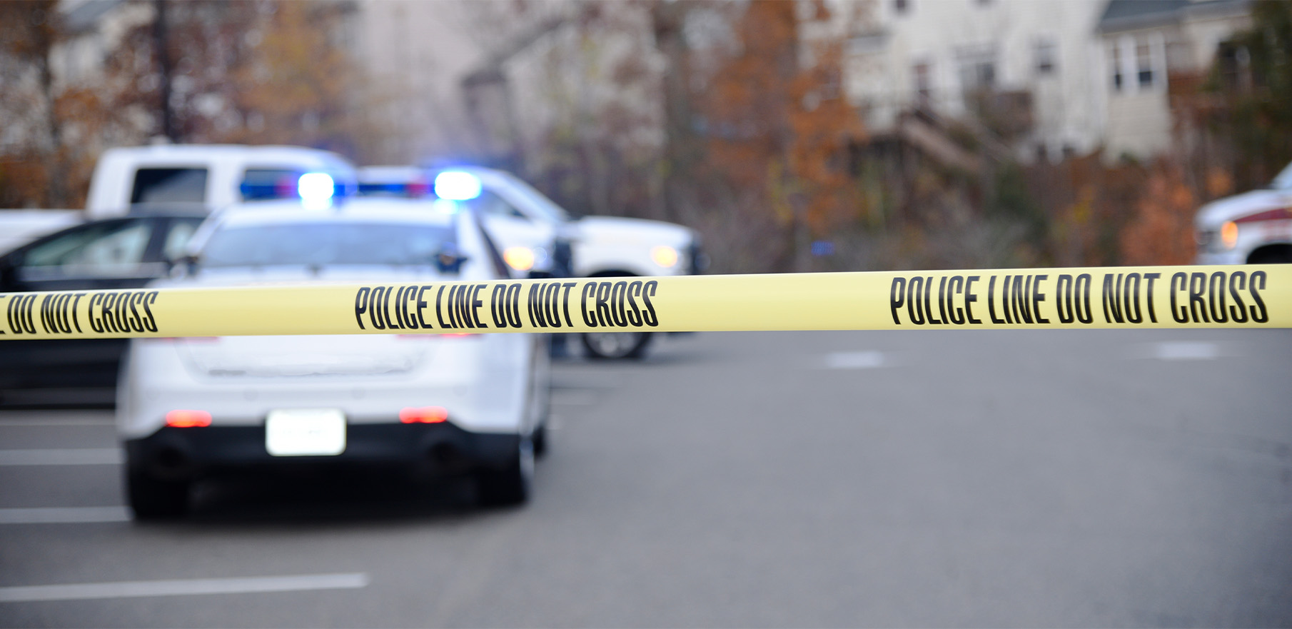 Police car in a parking lot with police tape