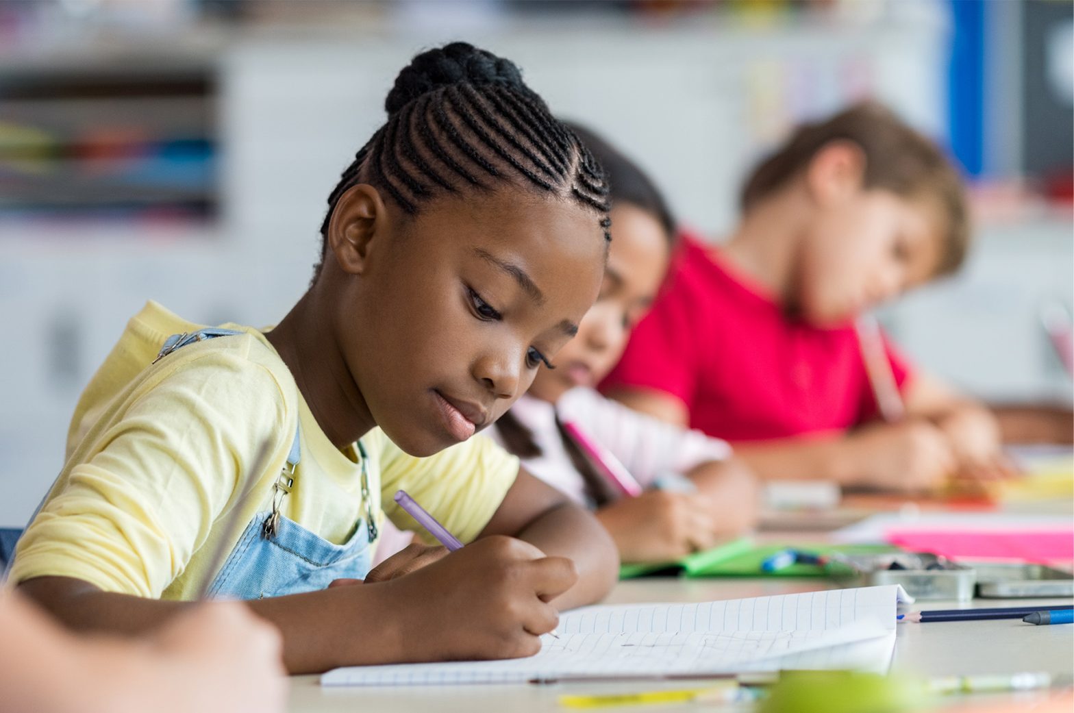 Elementary-aged kids in school writing