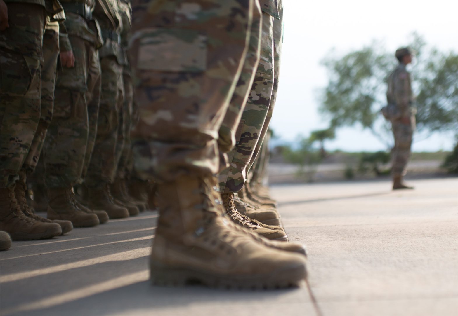A close-up of a group of soldiers in a line focused on their boots